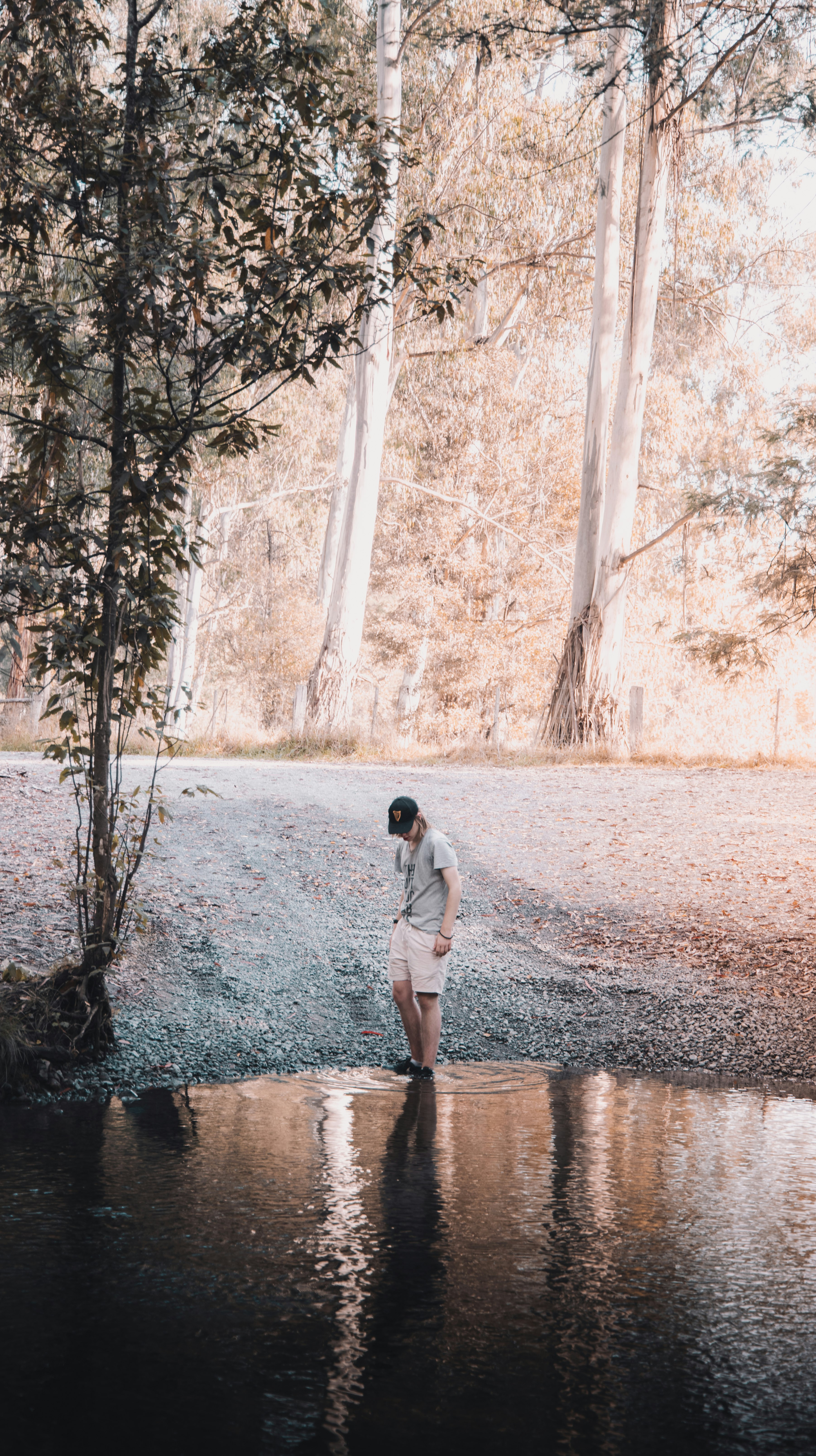 man in white shirt and gray pants walking on pathway during daytime